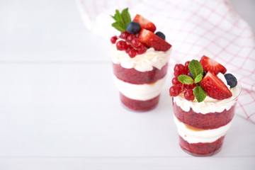 Trifle red velvet. Cake layered dessert in glass with fresh berry, mint leaves.
