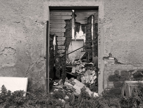 immagine desolata di abbandono, porta rotta su muro abbandonato