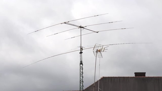 Antennas on roof with stormy clouds. Communication concept