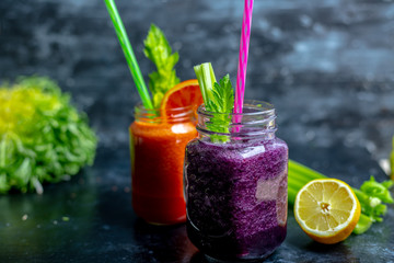 vegetable and fruit smoothies in various colors on a dark, warm background