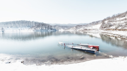 Old abandoned boat in winter lake