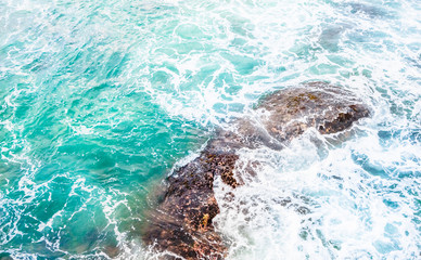 Obraz premium Texture of Turquoise sea with spray on stones