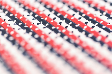 Fototapeta premium Dotted paper straws background close up, trendy coral red white and black with copy space. Beyond plastic concept and pattern
