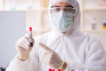 Young handsome chemist working in the lab 