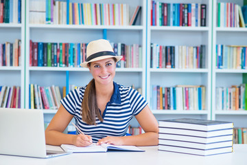 female student study in library using laptop and searching for informations on internet