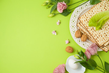 Jewish holiday Passover background with matzo, seder plate and spring flowers.