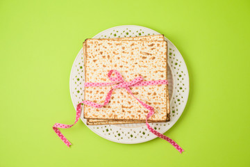 Jewish holiday Passover matzo on plate on green background.