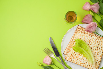 Jewish holiday Passover background with matzo, seder plate and spring flowers.