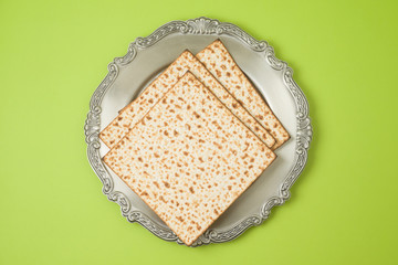 Jewish holiday Passover matzo and seder plate on green background.