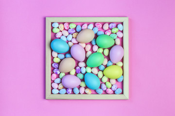 Square shaped Colorful Assorted sizes Pastel Eggs. Happy Easter card flat lay on bright pink festive background