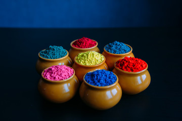 Colorful Holi powder in cups closeup. Bright colours for Indian holi festival in clay pots....