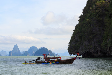 Naklejka na ściany i meble Longtail boat on a mountain lake in thailand