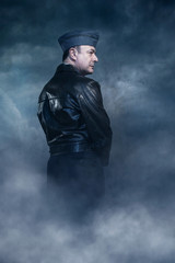 Retro world war 2 pilot under stormy sky. Side view.