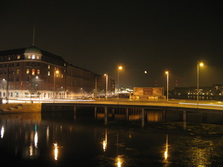 Puente, linternas reflejadas en el rio. Edificios en la noche iluminados con luz amarilla. Otoño Copenhague Dinamarca