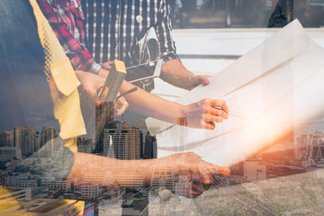 Double exposure of hand engineer with modern city background.meeting for architectural project working with partner and engineering tools on workplace.