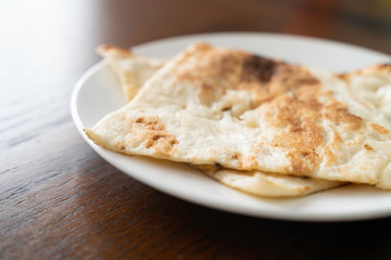 Pieces of Indian Nann bread on white plate
