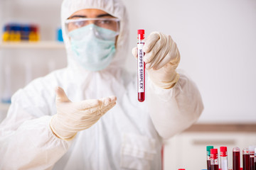 Young handsome lab assistant testing blood samples in hospital 