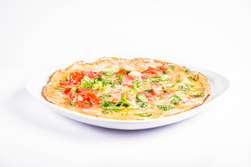 Omelette with tomatoes and fresh corn salad on a white background