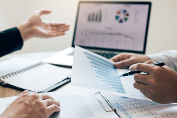 Colleagues are talking about the results in the documents on hand and compared with the financial information on the laptop screen.