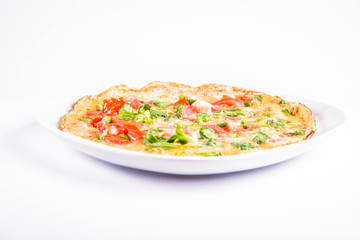 Omelette with tomatoes and fresh corn salad on a white background