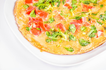 Omelette with tomatoes and fresh corn salad on a white background