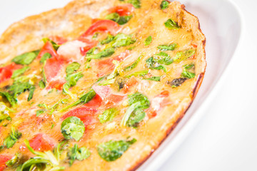 Omelette with tomatoes and fresh corn salad on a white background