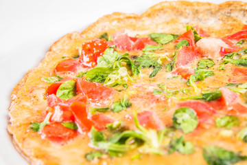 Omelette with tomatoes and fresh corn salad on a white background