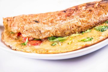 Omelette with tomatoes and fresh corn salad on a white background