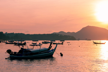 Fototapeta na wymiar fishing boat in the sea in morning time with beautiful sunrise and reflection in the water at phuket andaman sea thailand