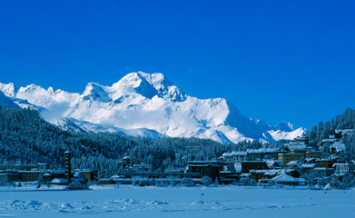 Swiss alps: View from frozen Lake St. Moritz to the bright shining Piz Maloja in the Upper Engadin