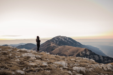 Donna in cima alla montagna guarda il panorama da sola, in Trentino