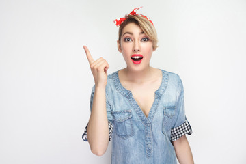 I have Idea. Portrait of excited beautiful young woman in casual blue denim shirt with makeup and red headband standing, amazed and looking at camera. indoor studio shot, isolated on white background.