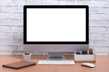 Blank screen of All in one Computer with tablet and cactus pot on wooden table, White brick wall background