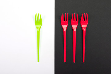 Bright green and red forks isolated on black and white background