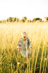 Boy, photographed on the field, among the yellow spikelets