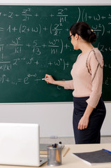 Female teacher standing in front of chalkboard   