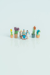 Miniature figurines - 3 generations of people on white background.