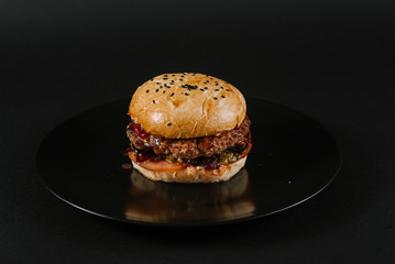 Tasty burger on the black background