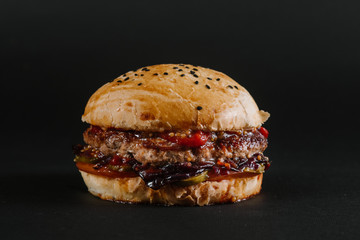 Tasty burger on the black background