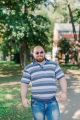 .Young man with round glasses and overweight in the park.