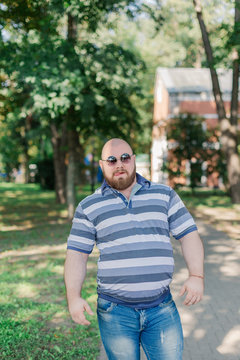 .Young man with round glasses and overweight in the park.