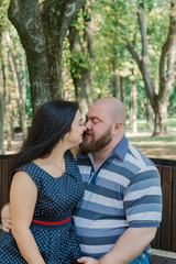 Two people in love sit on a bench in the park.