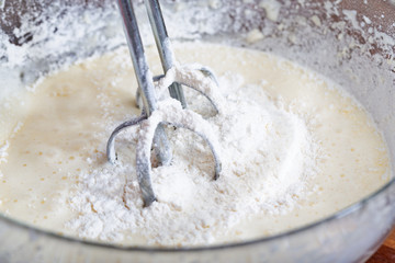 The mixer nozzle is immersed in a pie dough