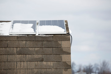 Two solar panels on a small building in winter