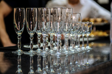 close up photo of rows of empty glasses for champagne on the table