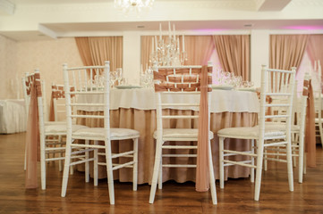 close up photo of a table in a banquet hall in white and brown colors decorated for the event