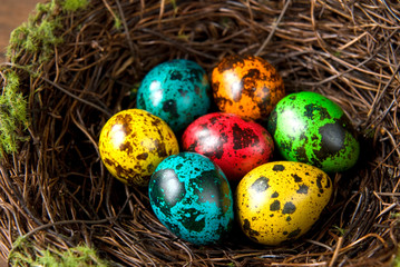 Fototapeta na wymiar Easter eggs in the decorative nest on wood background