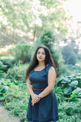 Fototapeta premium Plus size fashion model in casual clothes, overweight female body in a park outdoors.