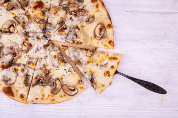 The pizza cut on pieces with champignons in creamy sauce