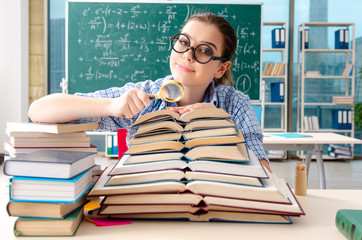 Female student with many books sitting in the classroom